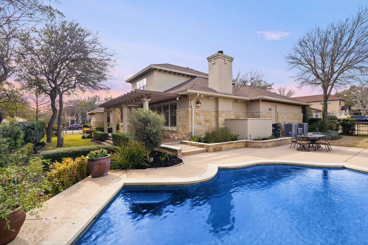 Custom home backyard pool with stone accents and outdoor seating by J Bryant Boyd, Georgetown, TX