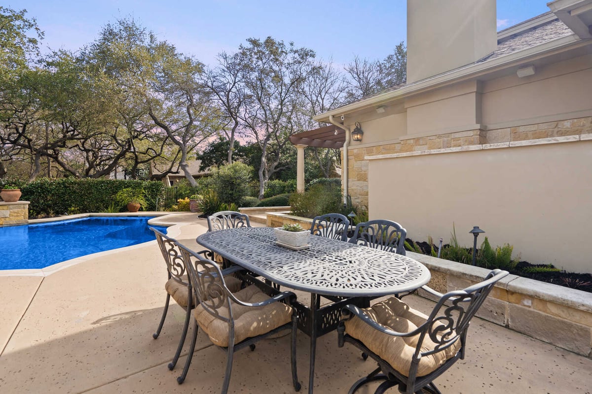 Custom home outdoor dining area near pool by J Bryant Boyd in Georgetown, TX