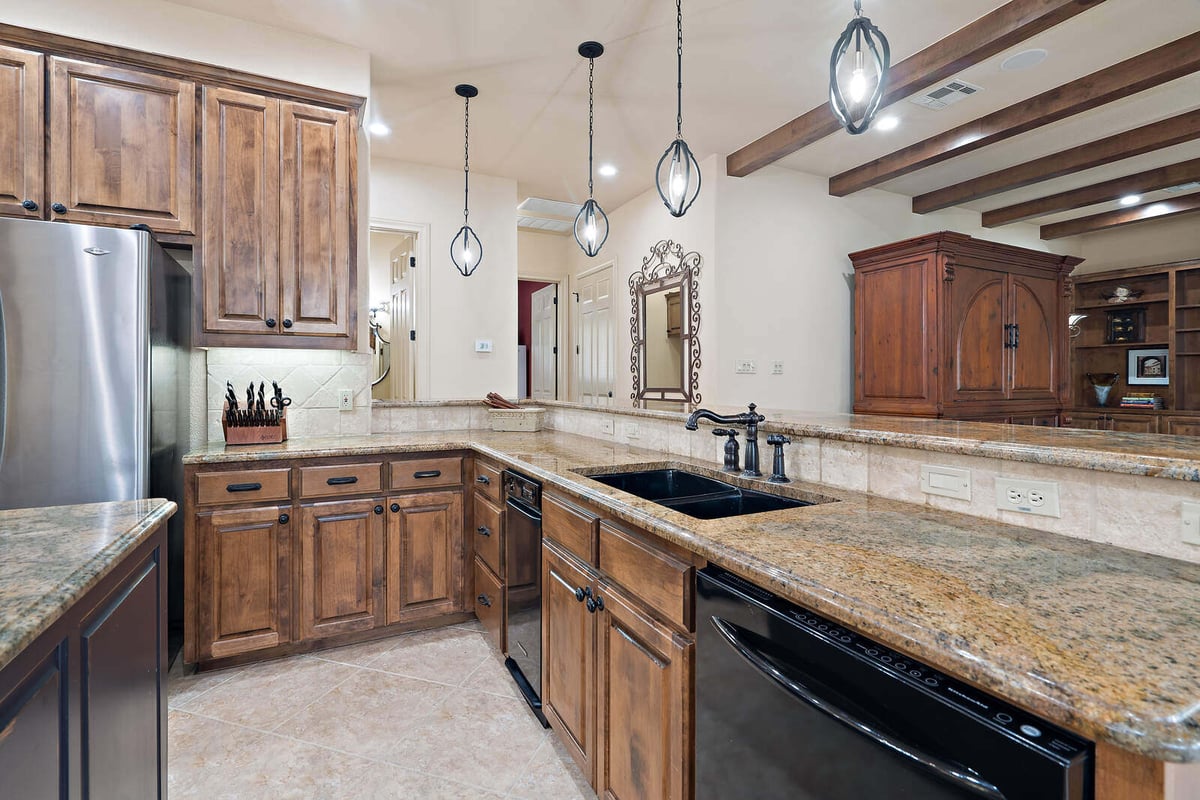 Custom kitchen with wood cabinets and granite countertops in a J Bryant Boyd home in Georgetown, TX-1