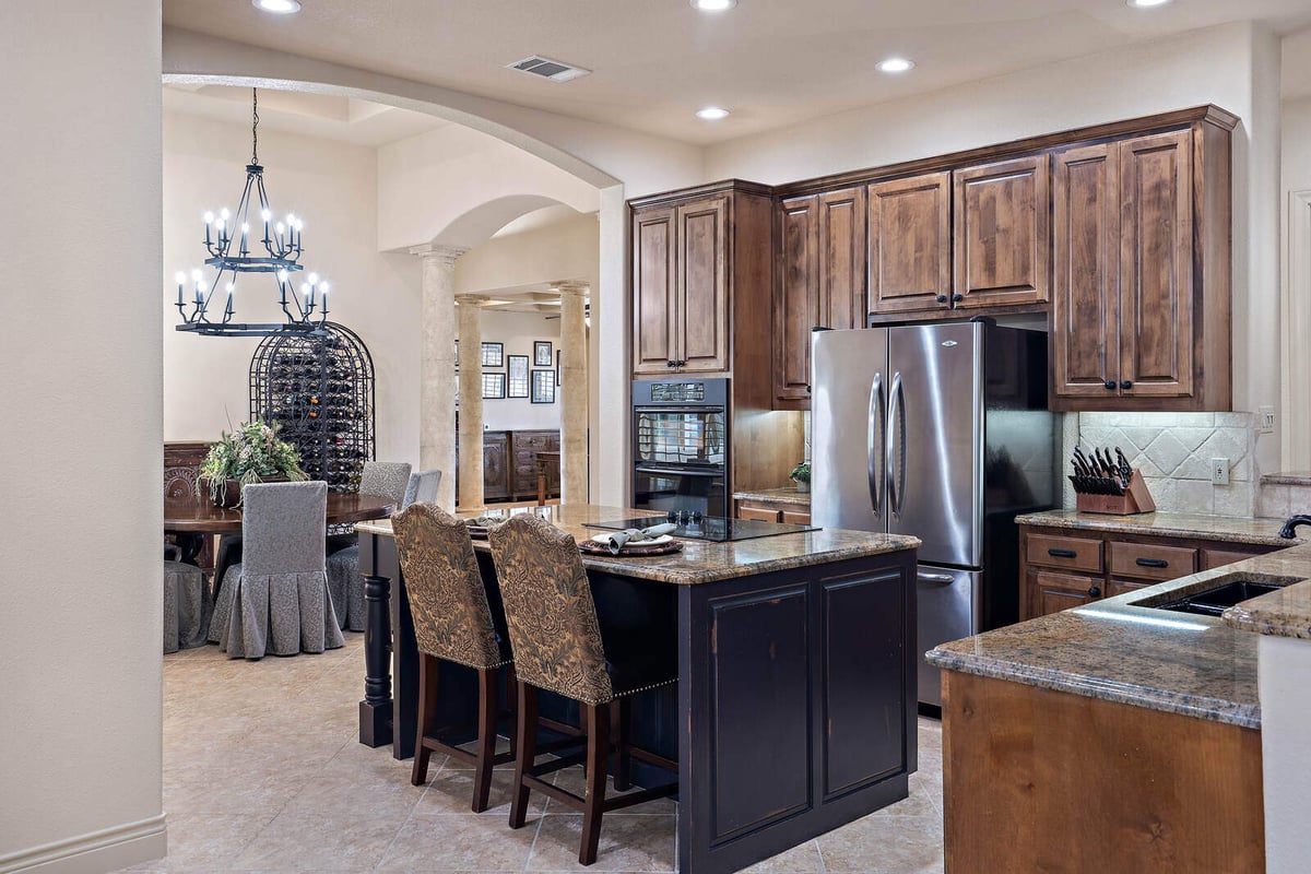 Dining area adjacent to a custom kitchen with granite countertops in a J Bryant Boyd home in Georgetown, TX-1