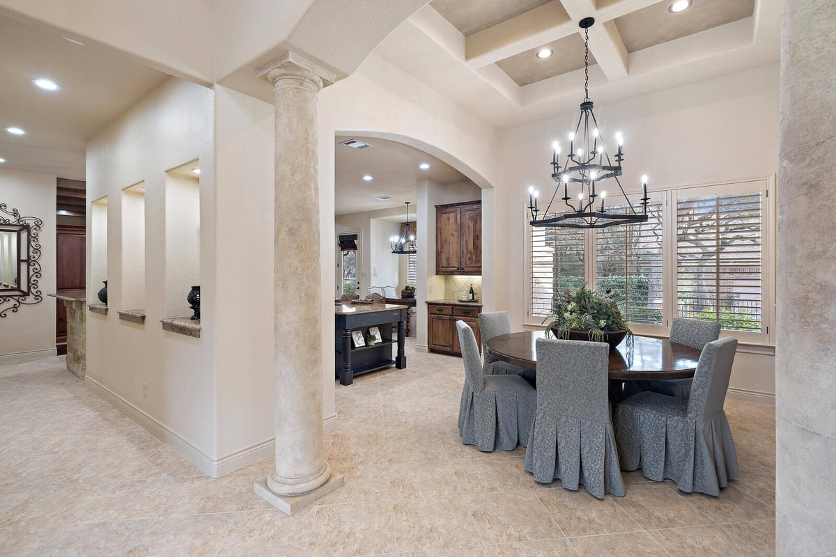 Dining area with chandelier and arched entryways in a custom home by J Bryant Boyd in Georgetown, TX-1