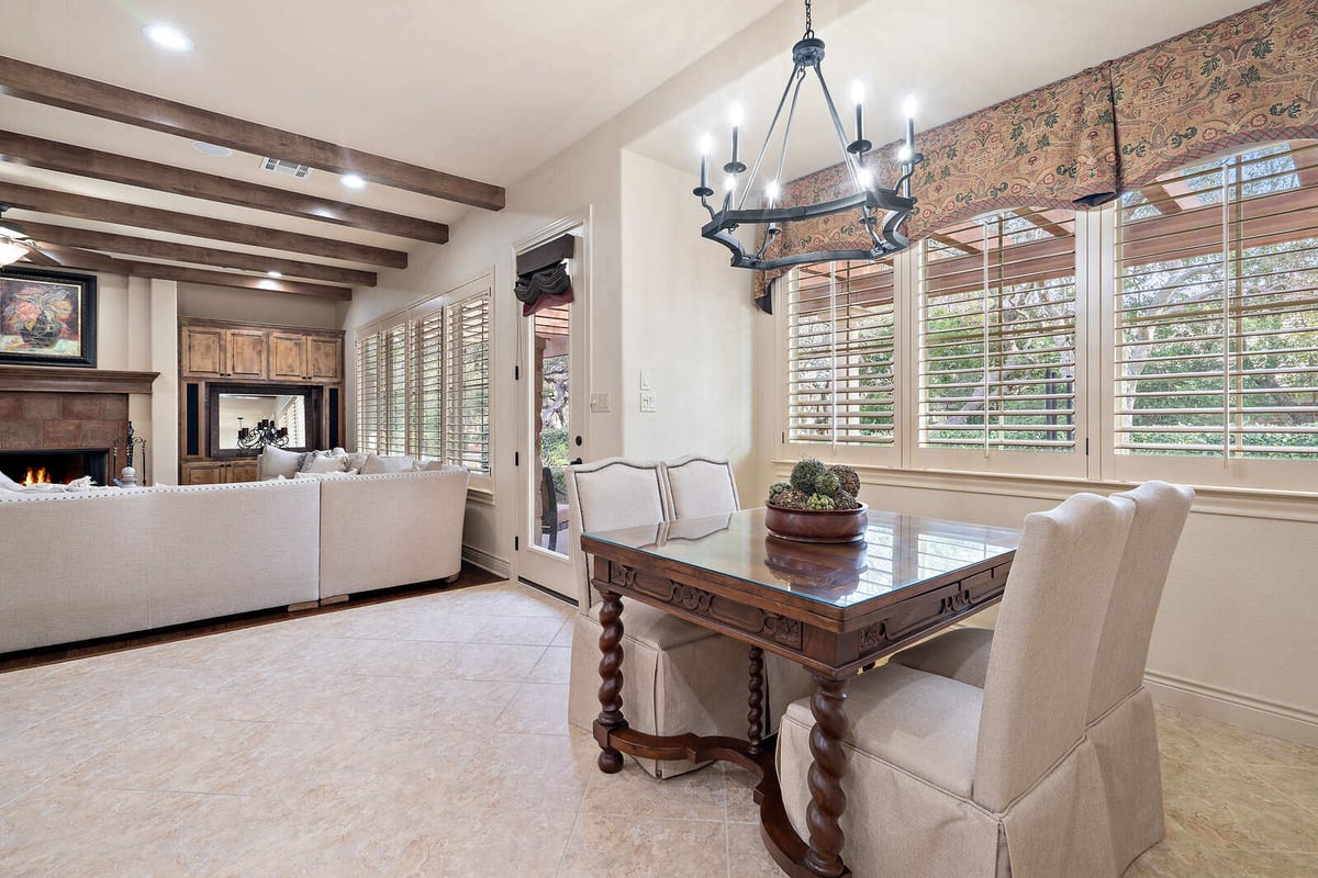 Dining area with rustic wood table and chandelier in a J Bryant Boyd custom home in Georgetown, TX-1