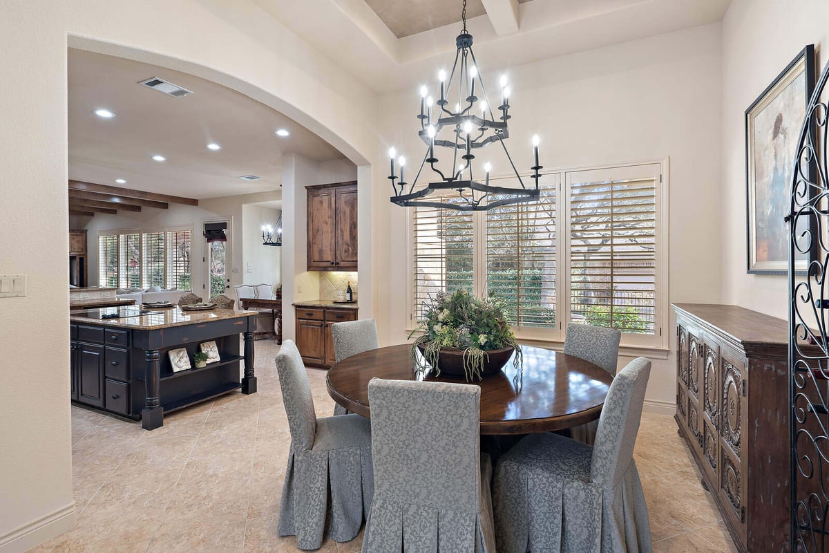 Dining room with round table and chandelier in a custom home by J Bryant Boyd in Georgetown, TX