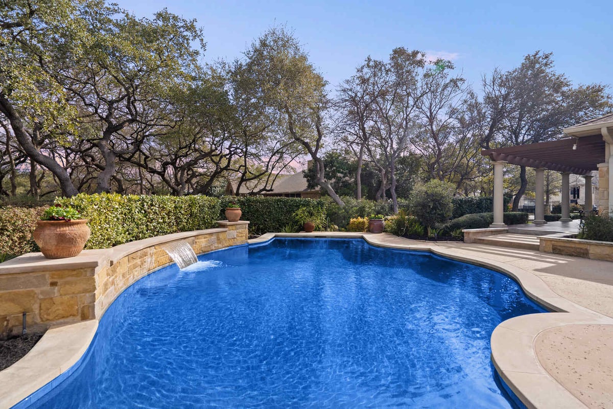 Elegant custom home pool with stone waterfall and lush landscaping by J Bryant Boyd, Georgetown, TX-1