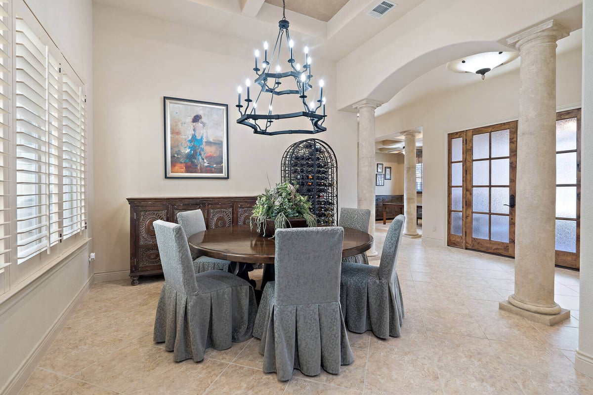 Elegant dining room with chandelier and round table in a custom home by J Bryant Boyd in Georgetown, TX-1