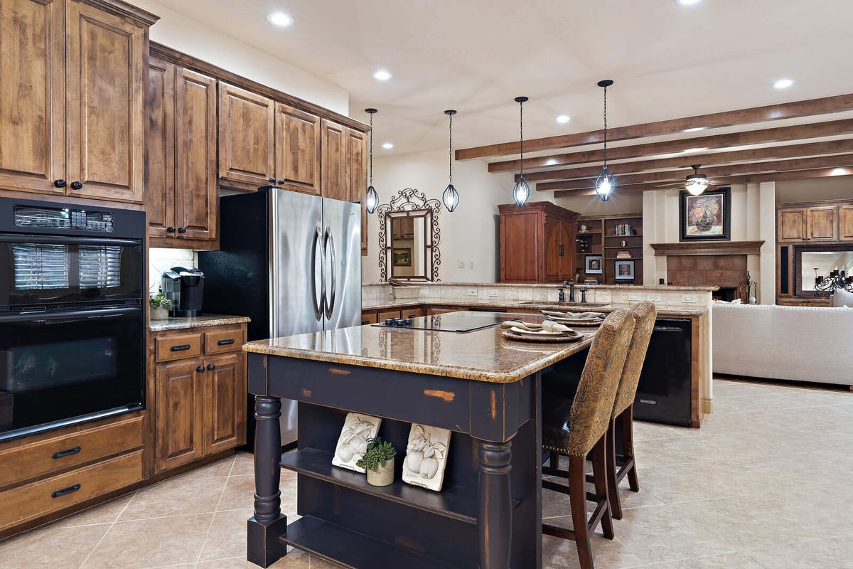 Elegant kitchen and dining area in a custom home by J Bryant Boyd in Georgetown, TX, with a large chandelier and rustic decor
