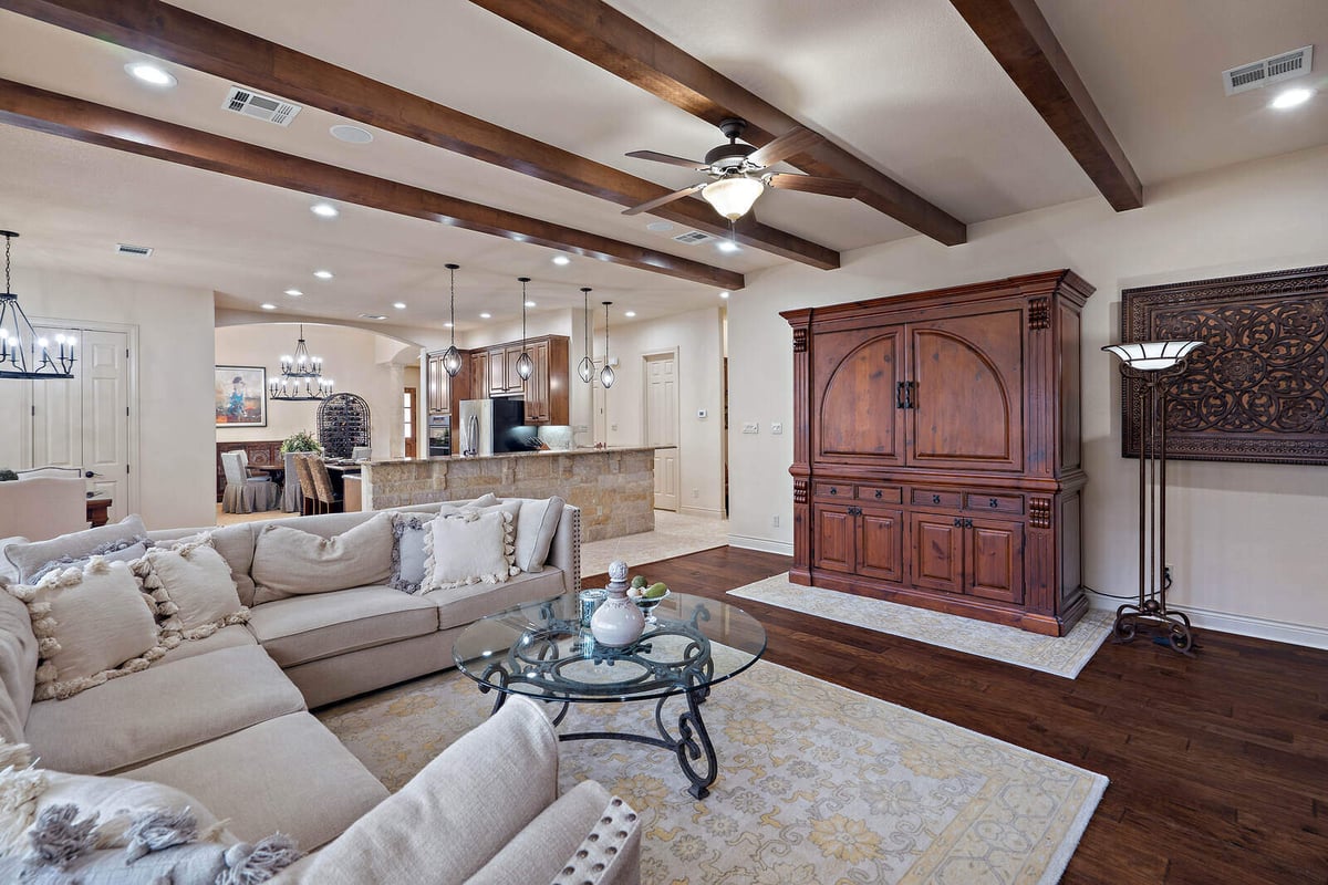 Elegant living room with wood accents and ceiling fan in a J Bryant Boyd custom home in Georgetown, TX-1