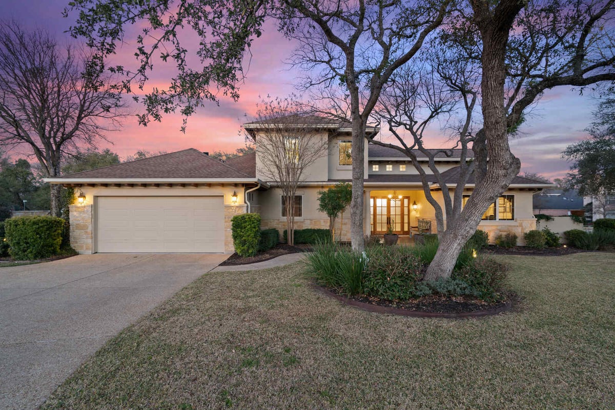 Well-lit custom home with a two-car garage and landscaped yard in Georgetown, TX by J Bryant Boyd